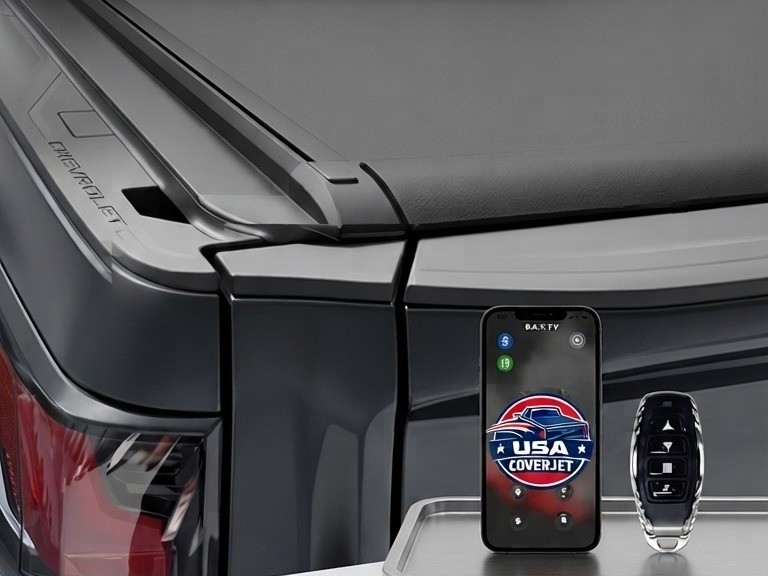 Hand holding a phone with the Coverjet app open next to the remote control, controlling the CJ-500 tonneau cover